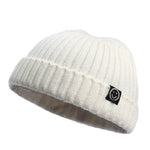 White knit beanie with a smiley face logo on a white background