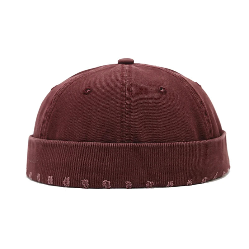 Wine red cap with embroidered details on a white background