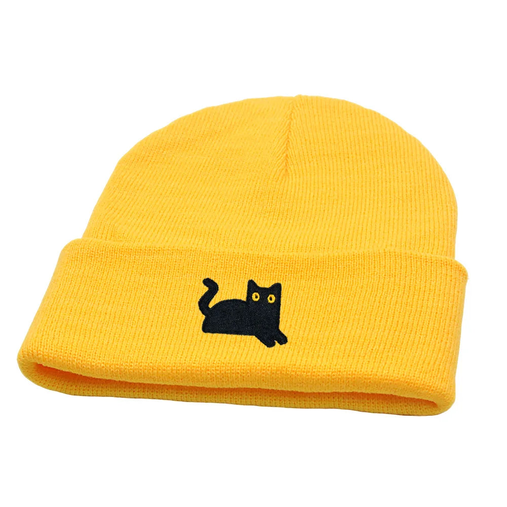 Yellow beanie with a black cat embroidery on a white background