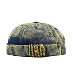 Distressed denim cap with gold embroidery on a white background