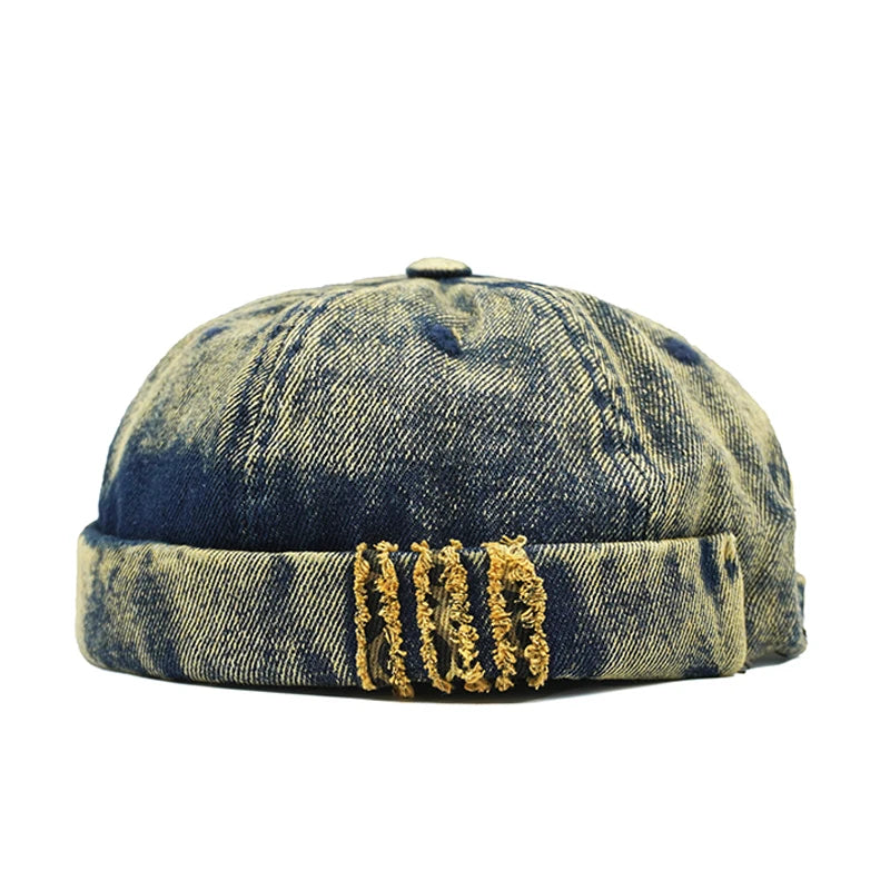 Distressed denim cap with gold embroidery on a white background