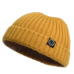 Yellow knit beanie with a black logo on a white background