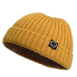 Yellow knit beanie with a black logo on a white background