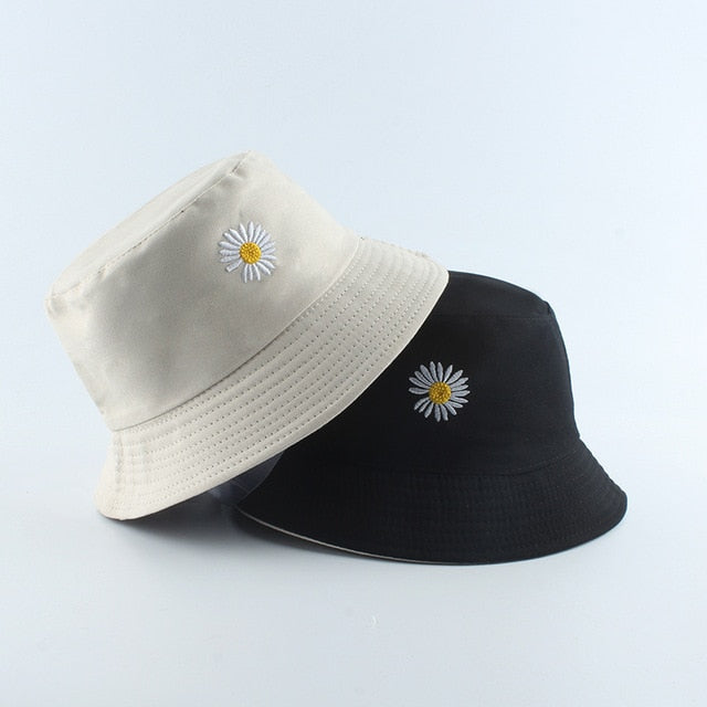 Beige And Black Bucket hat shown stacked in beige and black colorways with daisy embroidery
