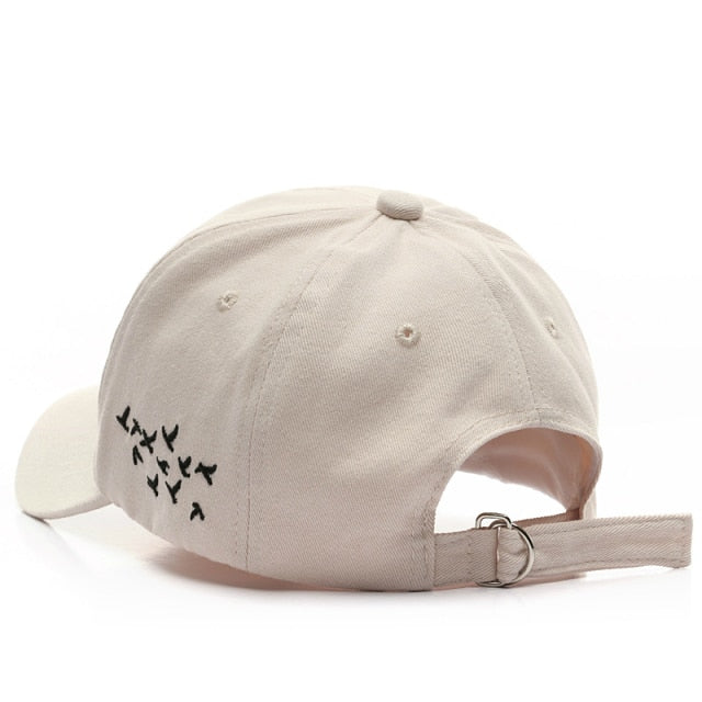Beige Birds hat back view showing embroidered flock design and adjustable strap