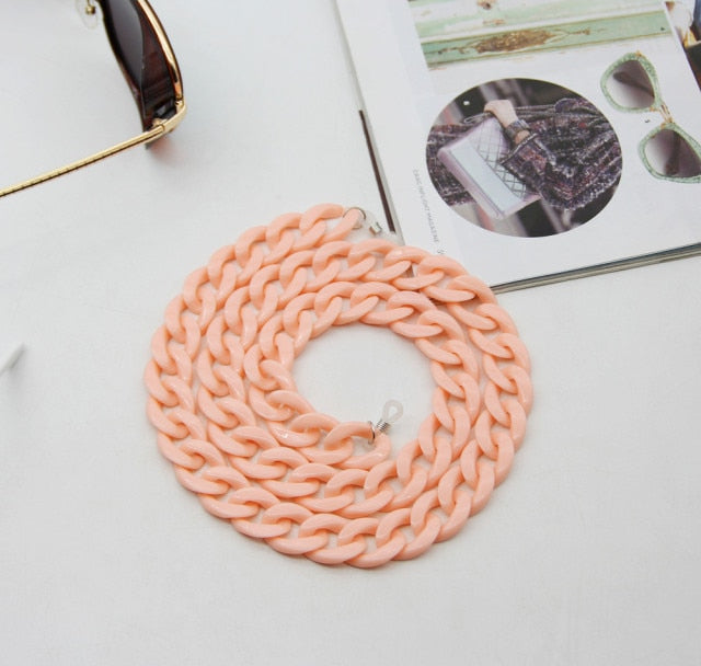 Beige Glasses chain coiled flat lay with sunglasses and magazine nearby