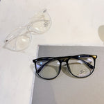 Black And Clear Blue light glasses laid flat showing two frame colorways side by side
