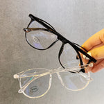 Black And Clear Blue light glasses held in hand stacked showing two frame colorways