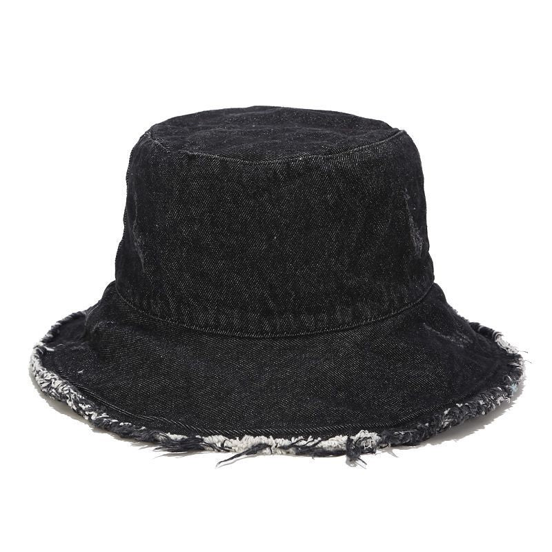 Black Distressed denim bucket hat angled view showing frayed brim edge and washed crown