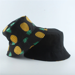 Black Bucket hat shown stacked revealing reversible pineapple print and solid interior