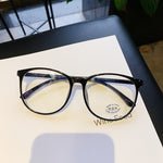 Black Blue light glasses laid flat on table showing round frame and clear lenses