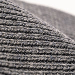 Charcoal Knitted beanie hat close-up of ribbed knit stitching and fold