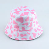Pink And White Bucket hat shown in front view with allover cow print pattern