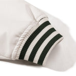 White Baseball jacket close-up of leather sleeve cuff with striped ribbing